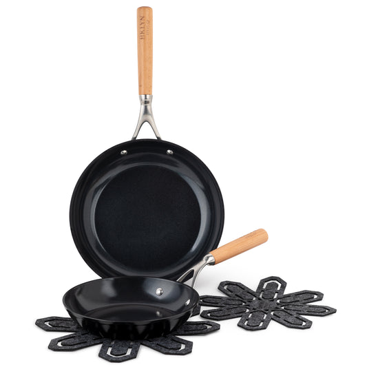 Two frying pans with beechwood handles and two cookware protectors