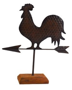 Metal rooster on a weathervane on top of a wood platform
